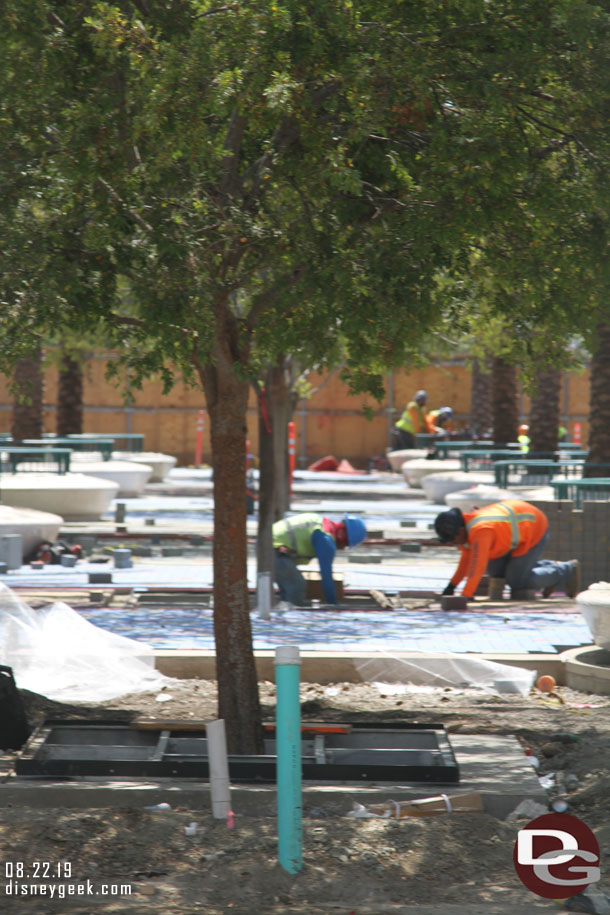 Paver installation continues in the new plaza area.