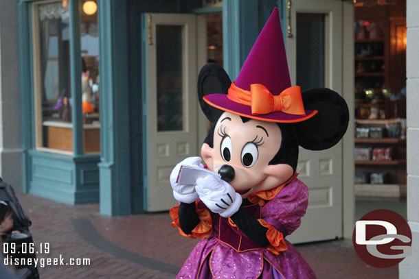 Minnie signing an autograph in her Halloween Costume