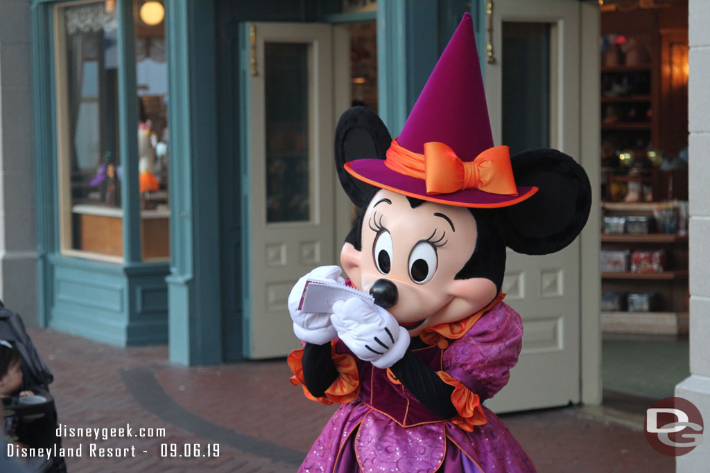 Minnie signing an autograph in her Halloween Costume