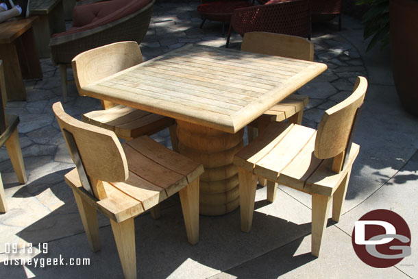 A table and chairs near the out door fireplace.