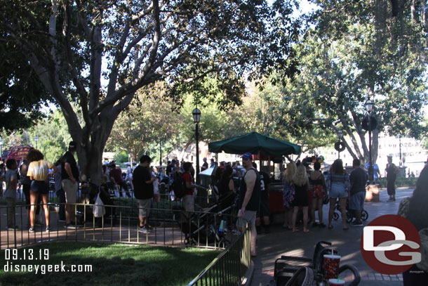 A couple dozen guests in line at the popcorn cart in New Orleans Square.