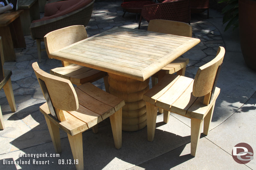 A table and chairs near the out door fireplace.