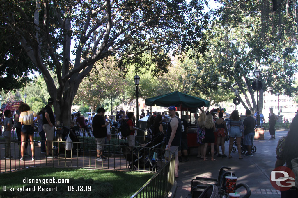 A couple dozen guests in line at the popcorn cart in New Orleans Square.