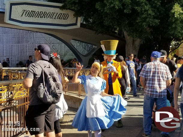 Alice and the Mad Hatter passing through Tomorrowland.