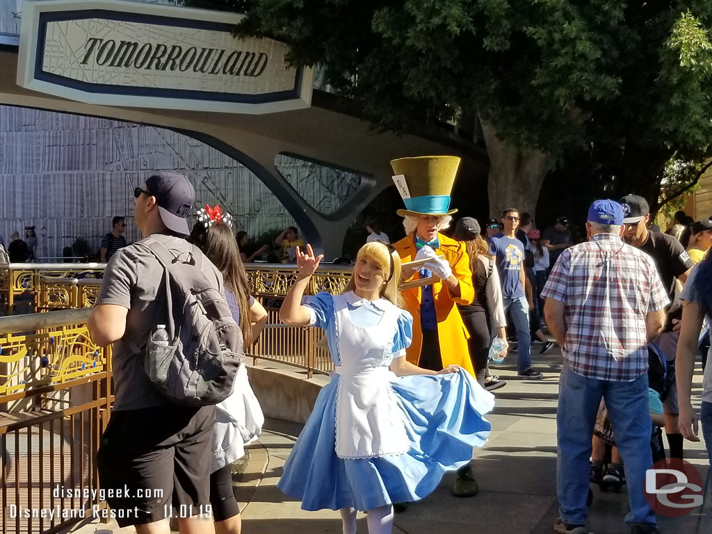 Alice and the Mad Hatter passing through Tomorrowland.