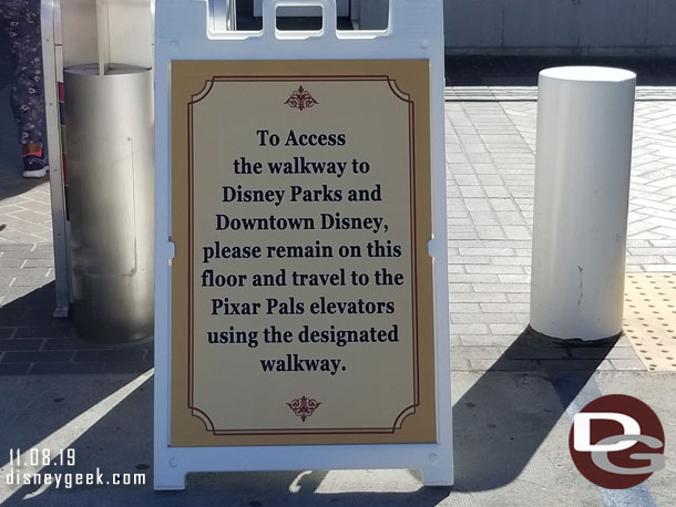 A sign directing those wanting to walk to walk around to the Pixar Pals structure and use the elevator their to reach the bridge.