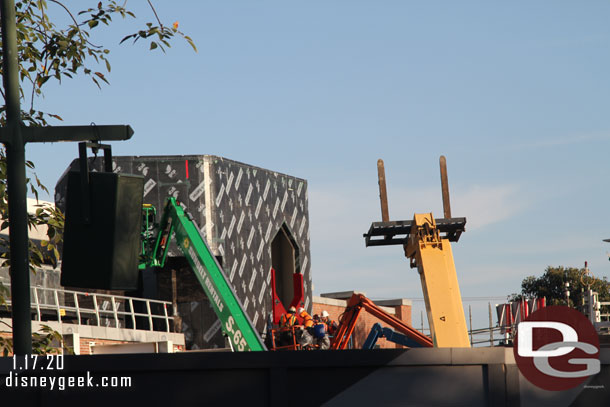 A team is installing the first element on this portion of the facade around the hexagon.