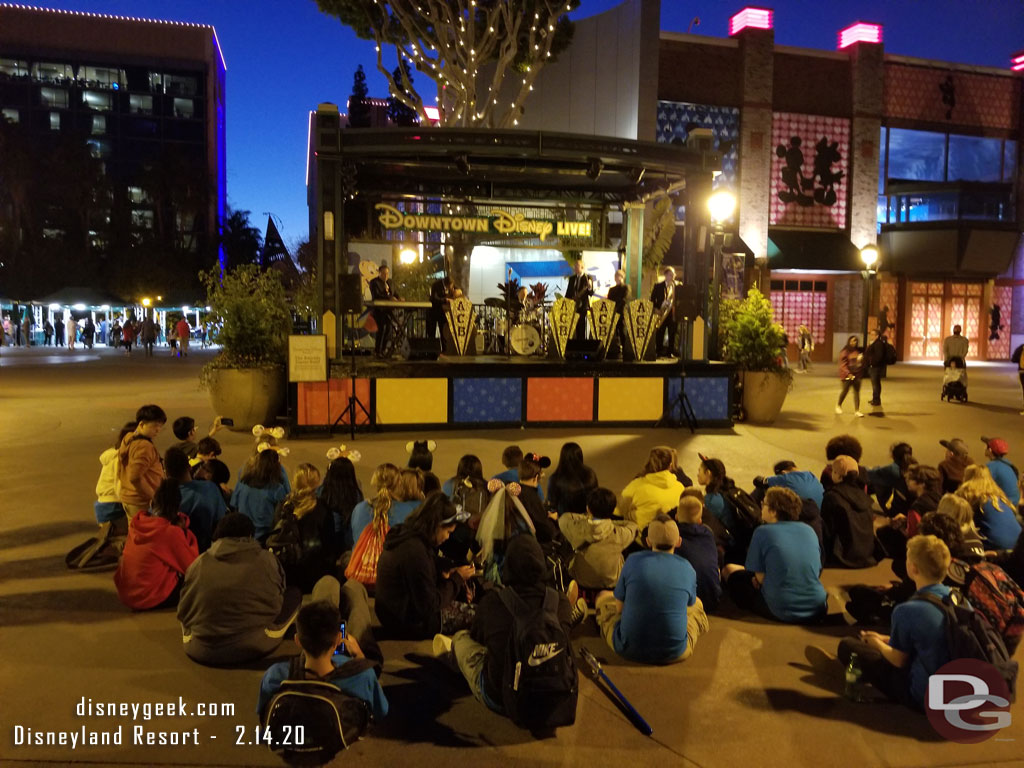 A group of sitting to watch the performance by the Amanda Castro Band this evening on the West End stage in Downtown Disney.