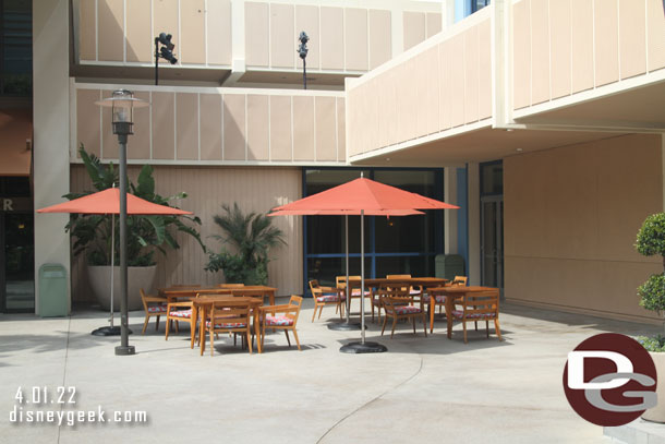 The chalk art is gone and tables/chairs have returned to the area.