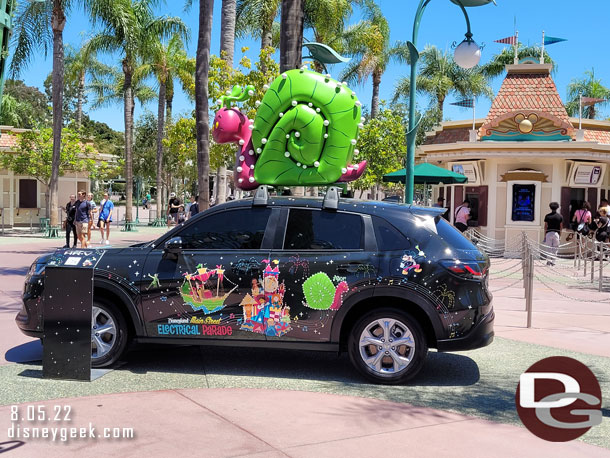 A Honda decked out for the 50th Anniversary of the Main Street Electrical Parade is parked near the ticket booths in the Esplanade.