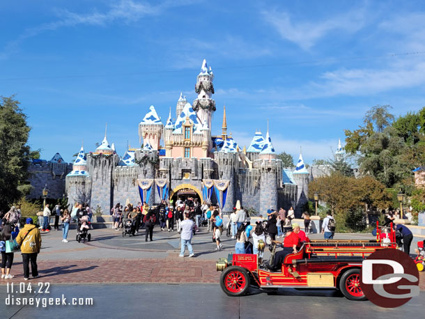 Sleeping Beauty Castle with the Disneyland Fire Truck stopped to pick up guests in front.