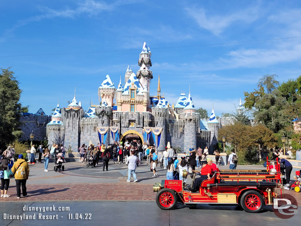 Sleeping Beauty Castle with the Disneyland Fire Truck stopped to pick up guests in front.