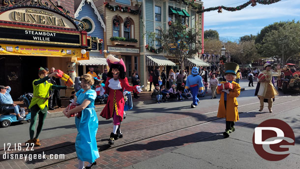 Peter Pan, Alice in Wonderland and Aladdin characters walking behind the bus.