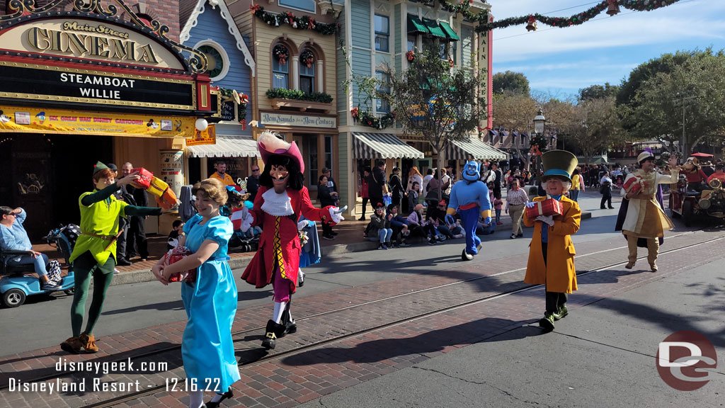 Peter Pan, Alice in Wonderland and Aladdin characters walking behind the bus.