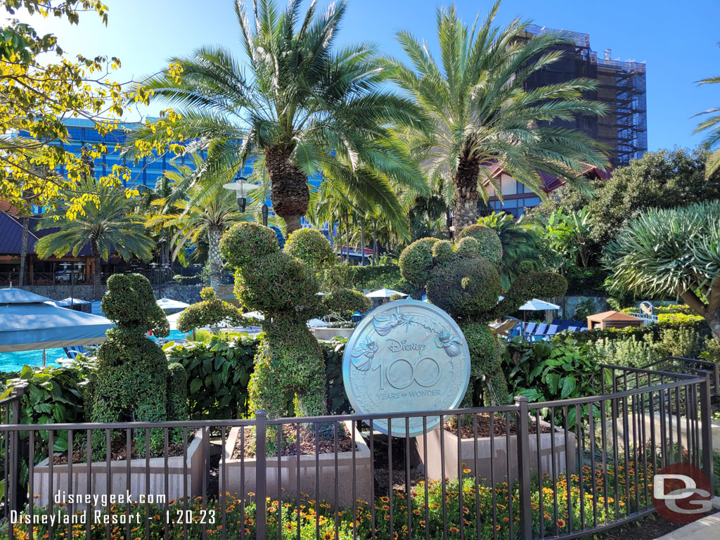 A Disney100 medallion added to the topiaries.