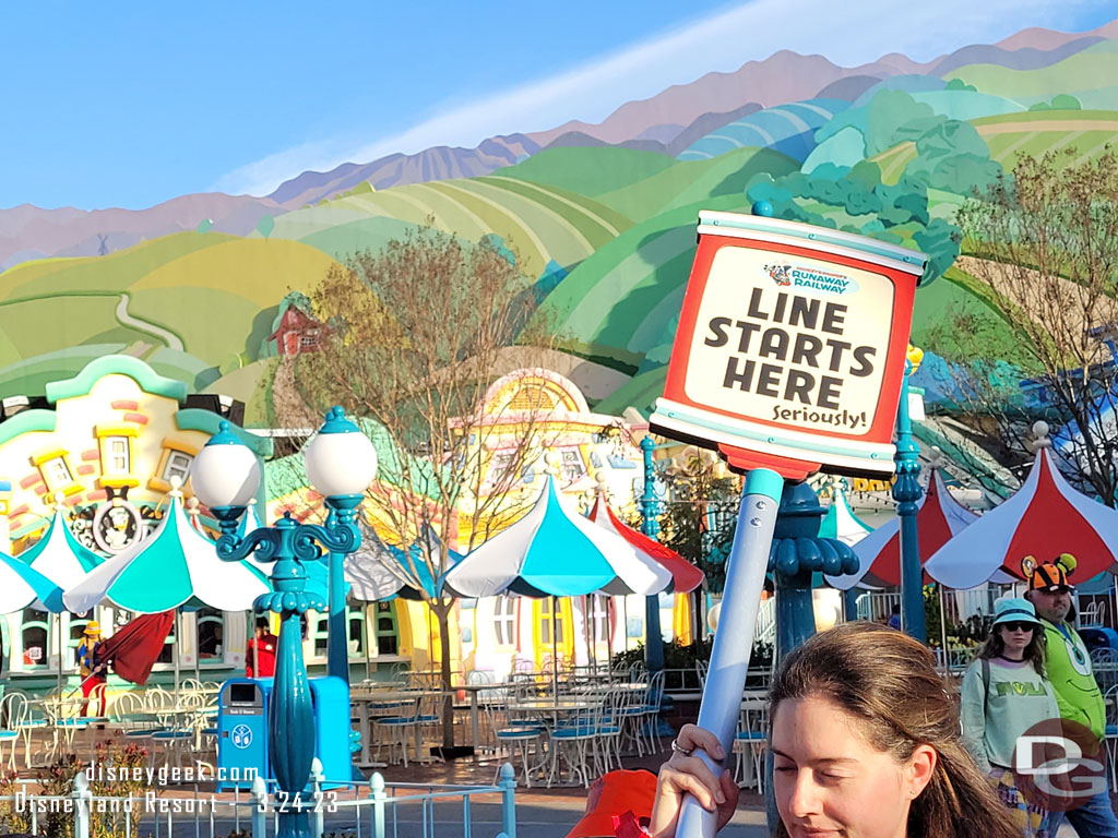 A cast member heading toward the end of the line that stretched toward Fantasyland at the moment.