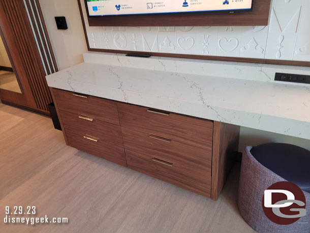 A counter and drawers under the TV