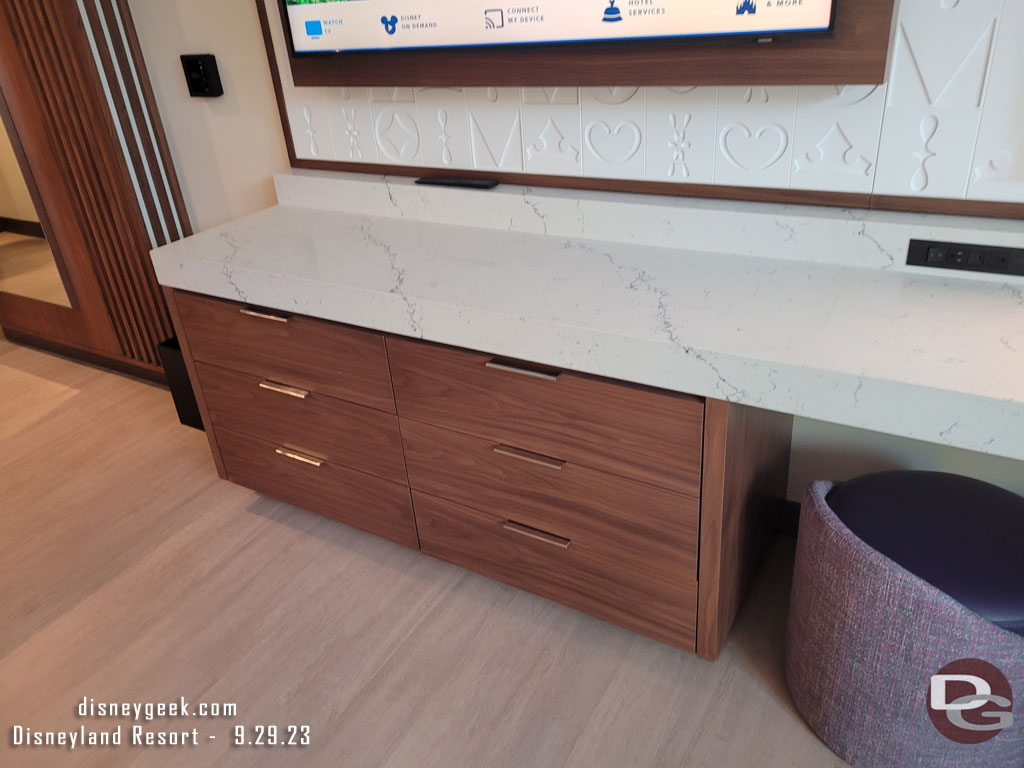 A counter and drawers under the TV