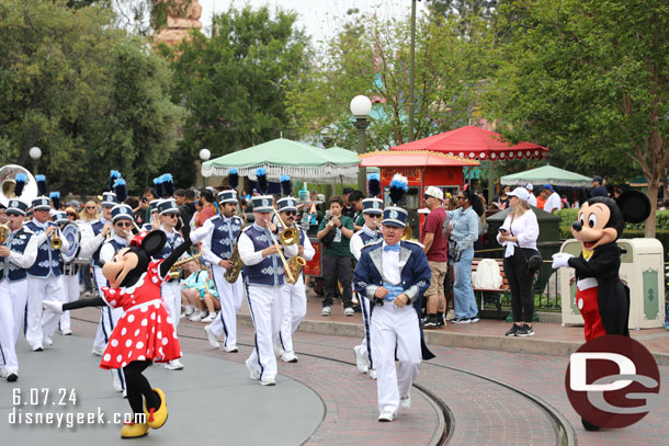 Mickey Mouse and Minnie Mouse leading the Disneyland Band on a march to Town Square