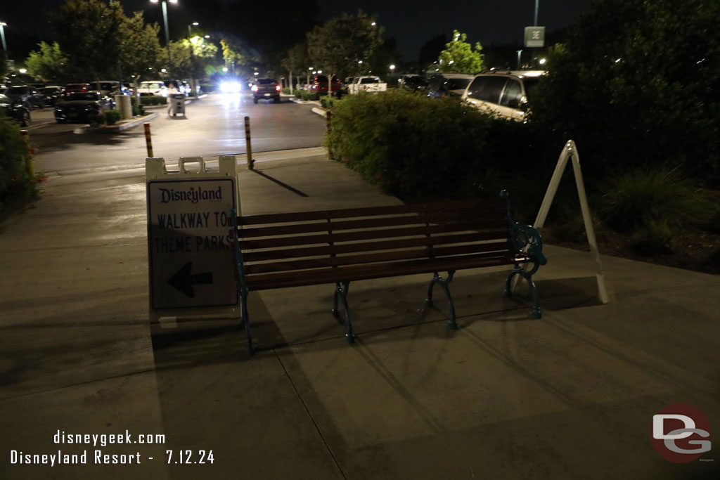 A-frames and a bench trying to convince you to stay on the walkway and not cut through parking lot.