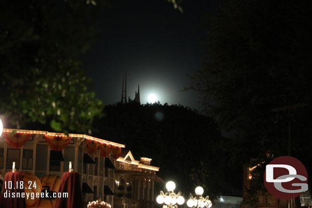 A bright full moon rising over Space Mountain