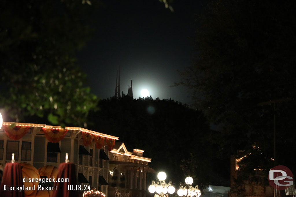 A bright full moon rising over Space Mountain