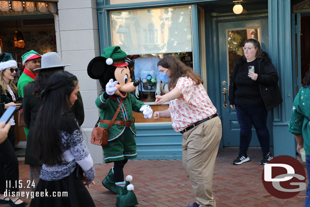 Mickey Mouse making his way out to take pictures with guests in his new Christmas outfit