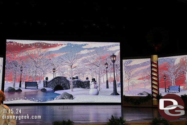 The backdrop on the stage are a series of large screens.