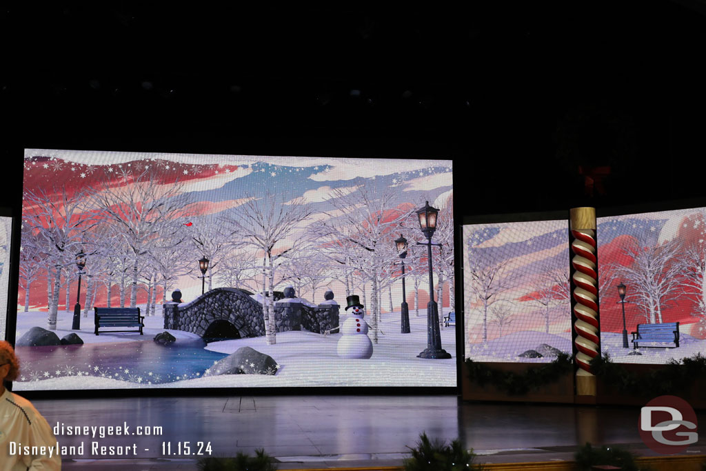 The backdrop on the stage are a series of large screens.