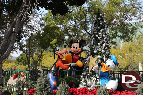 Mickey, Donald, Goofy, Chip N Dale decorating a tree near the tram stop.