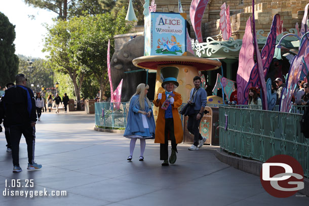 Alice and the Mad Hatter strolling through Fantasyland