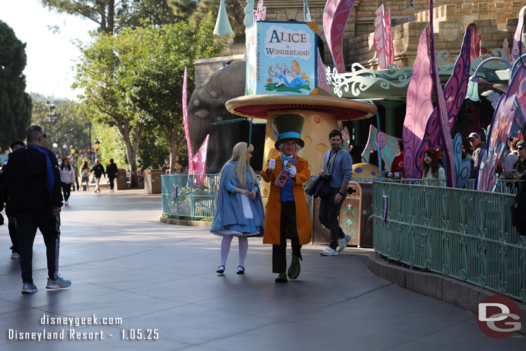 Alice and the Mad Hatter strolling through Fantasyland