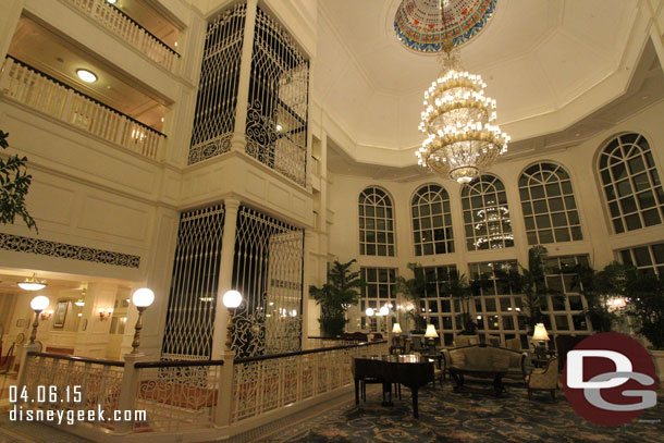 The central portion of the lobby features a glass elevator on one side and windows straight out the back.  To the left beyond the elevators is the front desk to the right the gift shop.