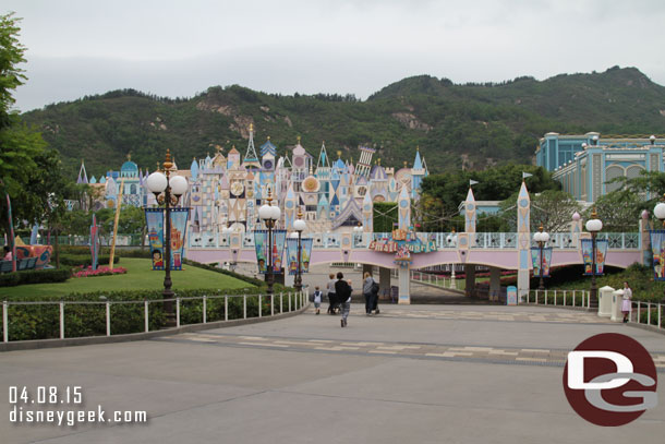 Approaching its a small world in Hong Kong Disneyland.  It is offset beyond the train tracks and with a mountain as the background. 