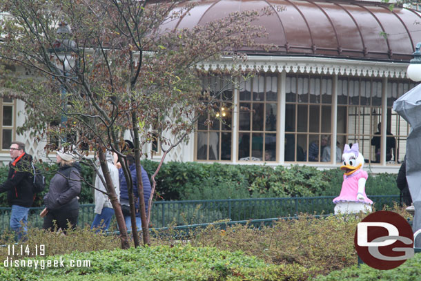 Daisy and Mickey (behind the tree and guests) heading to the Plaza Gardens Restaurant for breakfast.