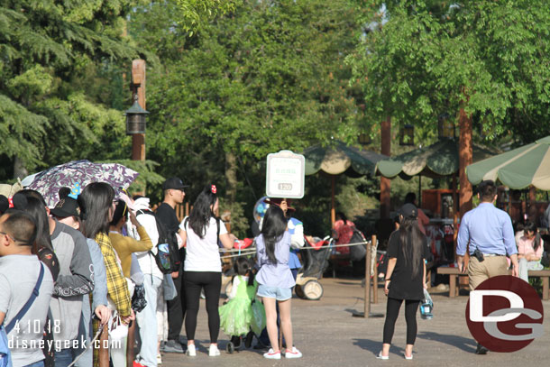 A cast member with a wait time sign at the end.. it says 120 minutes.