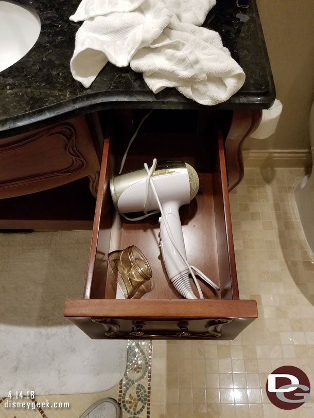 A hair dryer is in the drawer in the bathroom.