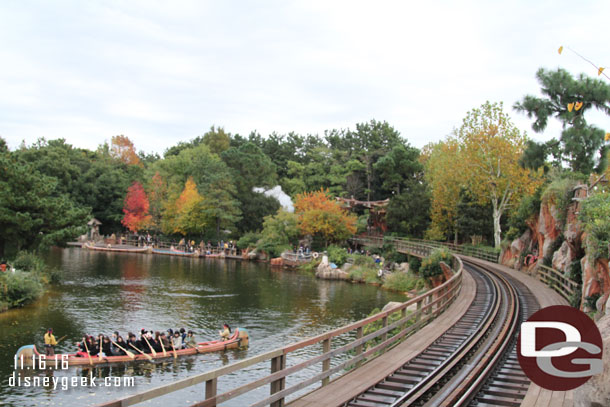 The Rivers of America as a train makes its way through the woods.