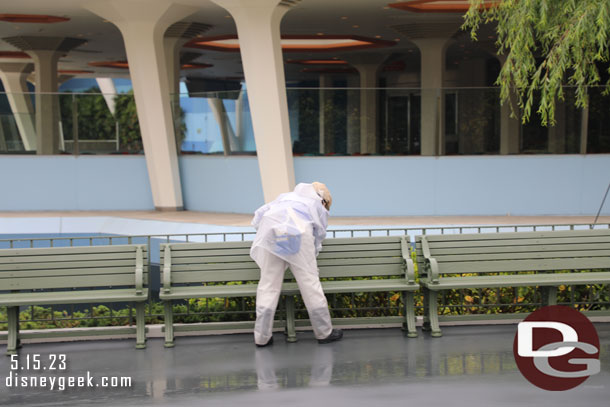 Cast member optimistically wiping down benches to dry them off.