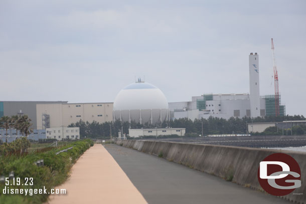 Looking down the road and across a channel at an industrial park.  The sphere is a gas company.