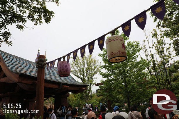 The first portion of the queue is outside through a small forest.
