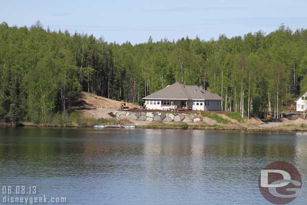 A large house under construction across the lake.