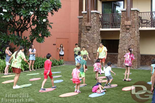 The kids were asked to hop on a surf board (carpets on the lawn).