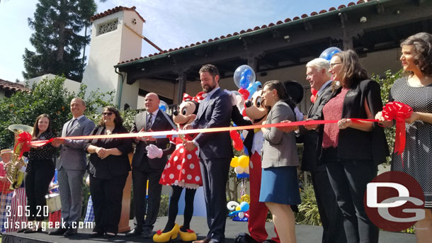 Representatives from the Walt Disney Archives & Bowers Museum assemble on stage for the ribbon cutting.