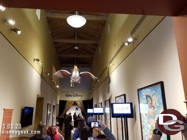 The corridor leading to the exhibit features video screens on one side playing an introduction while Dumbo soars overhead.