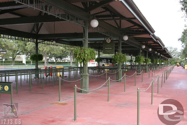 Not many people at the bus stop in the middle of the afternoon