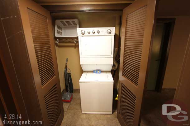 Across from the bathroom a closet with the laundry machines and vacuum.