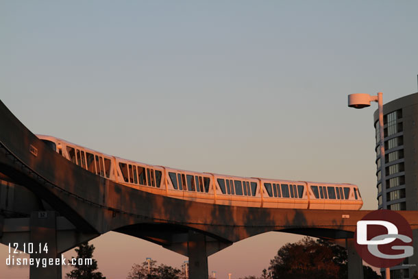 A Monorail gliding overhead as the sun is setting and I am walking to the Magic Kingdom