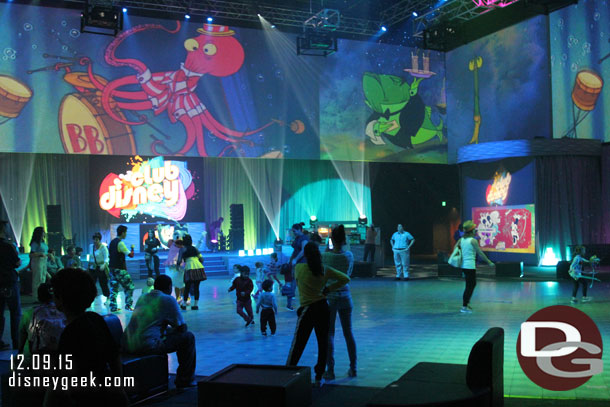 Inside the room is dominated by a large dance floor, projections above, and chairs around the perimeter.