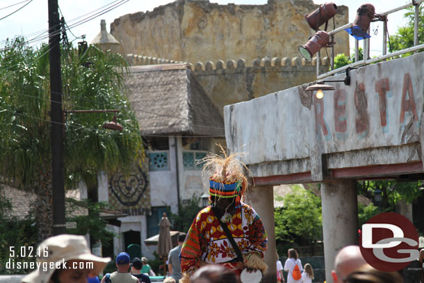 A performer on stilts making his way through Harambe.